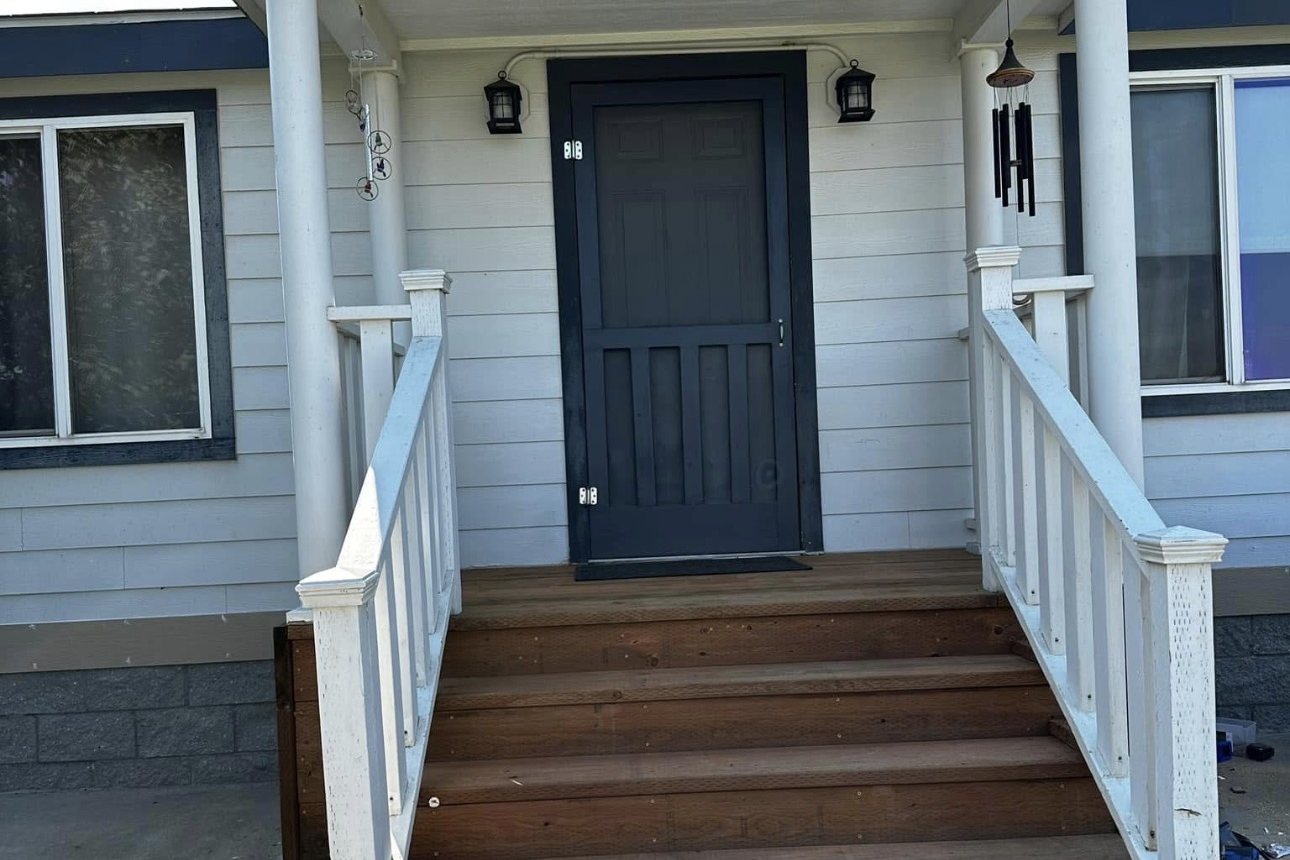 Front porch steps after the renovation, with new stained wood treads and fresh trim
