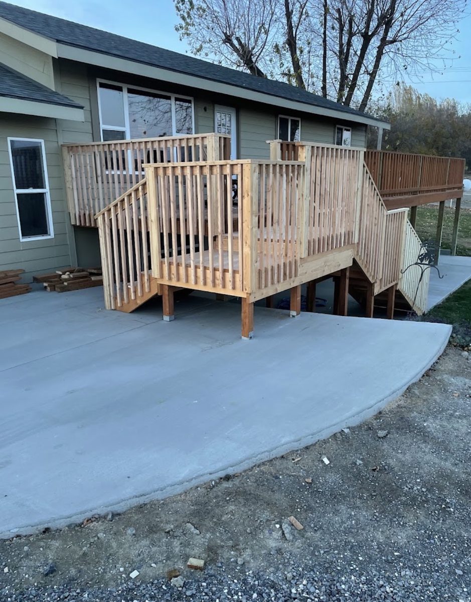 Elevated wood deck with fresh railings above a new concrete patio