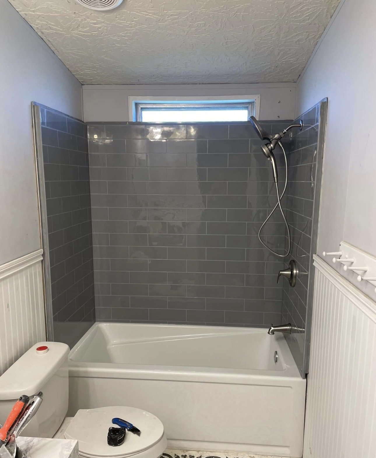 Finished bathroom remodel with a tiled tub and shower surround