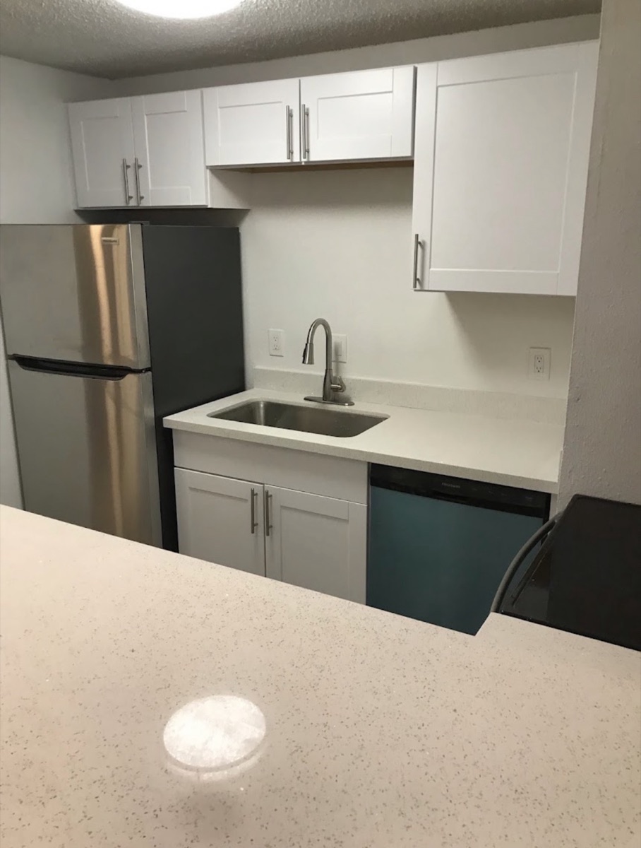 Finished white-cabinet kitchen remodel with new countertops and appliances